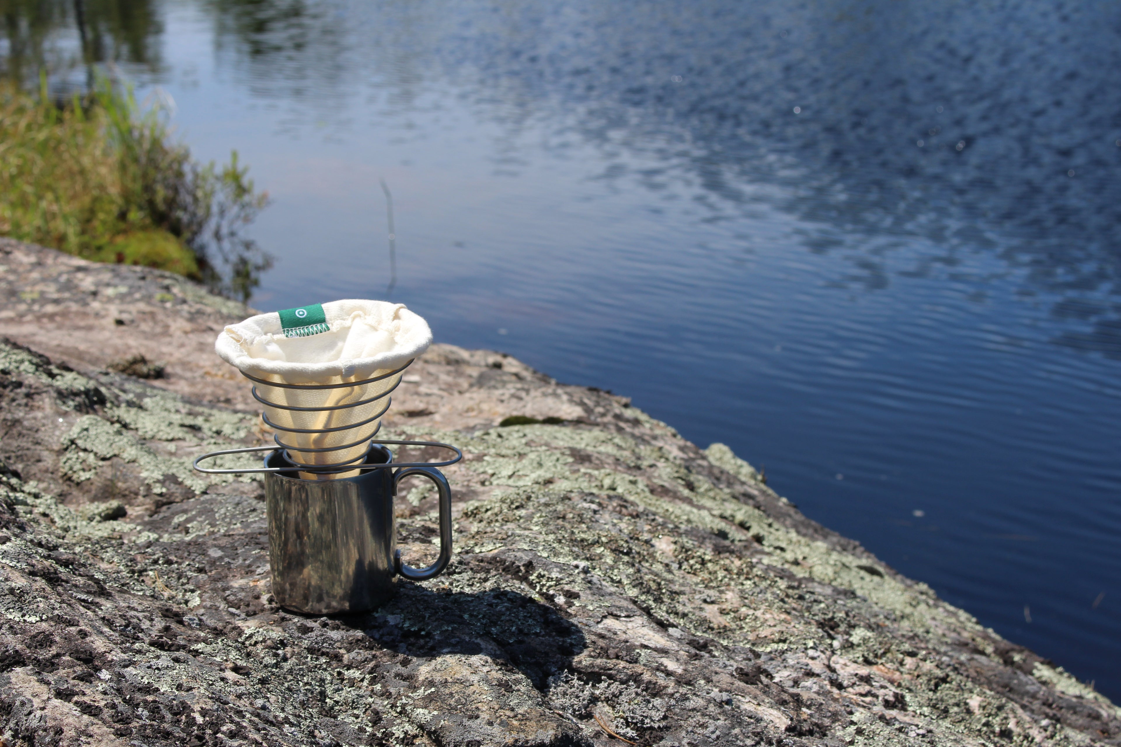 ACE Brewer filter resting on stainless frame beside lake